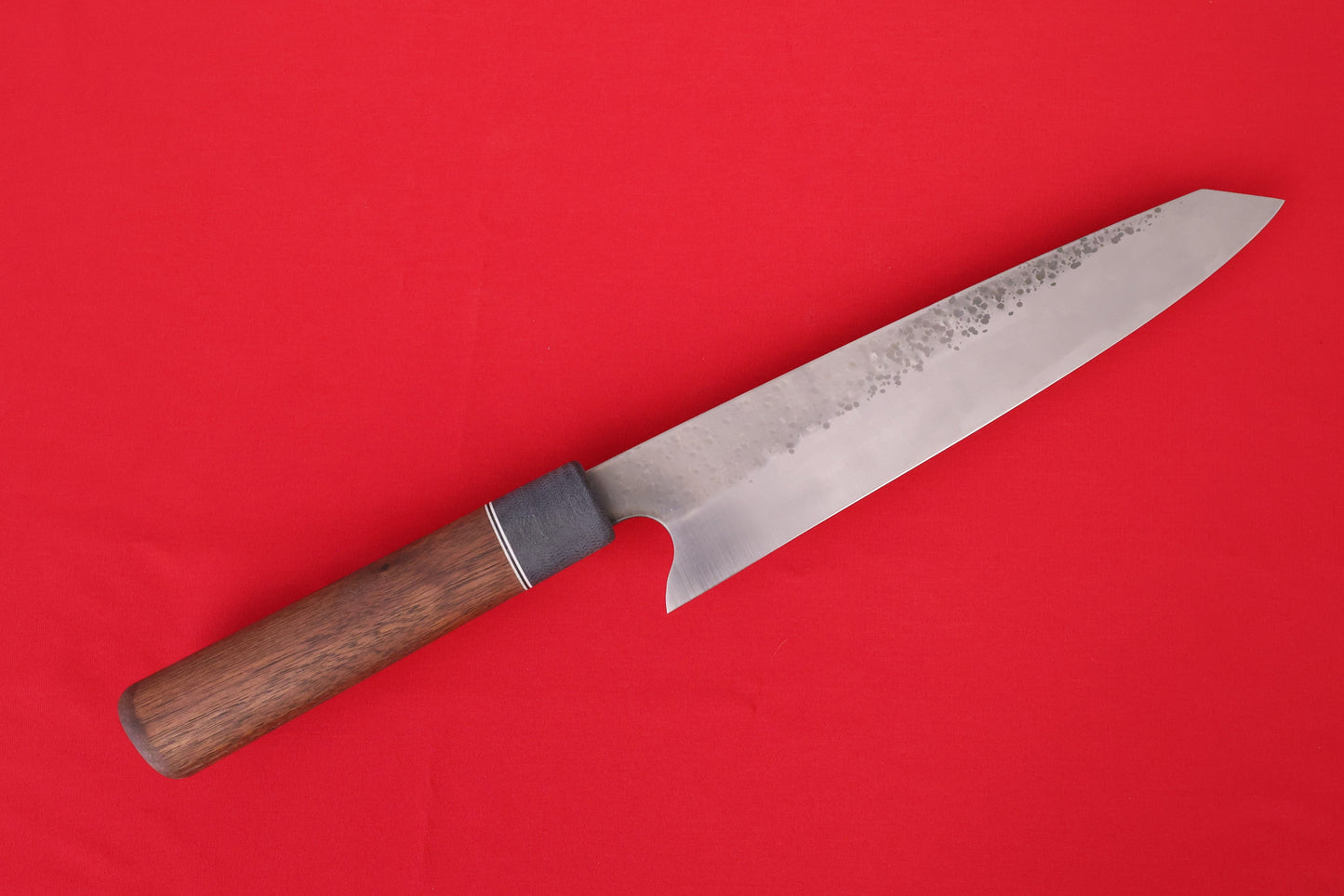large kitchen knife on red background. Stainless steel with Walnut handle.
