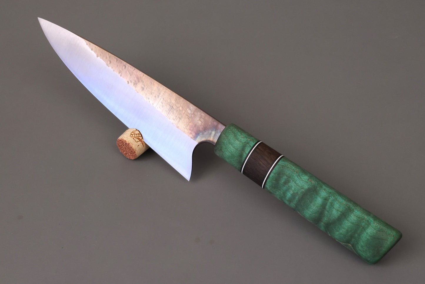 Chef/Gyuto kitchen knife with green handle on gray background.