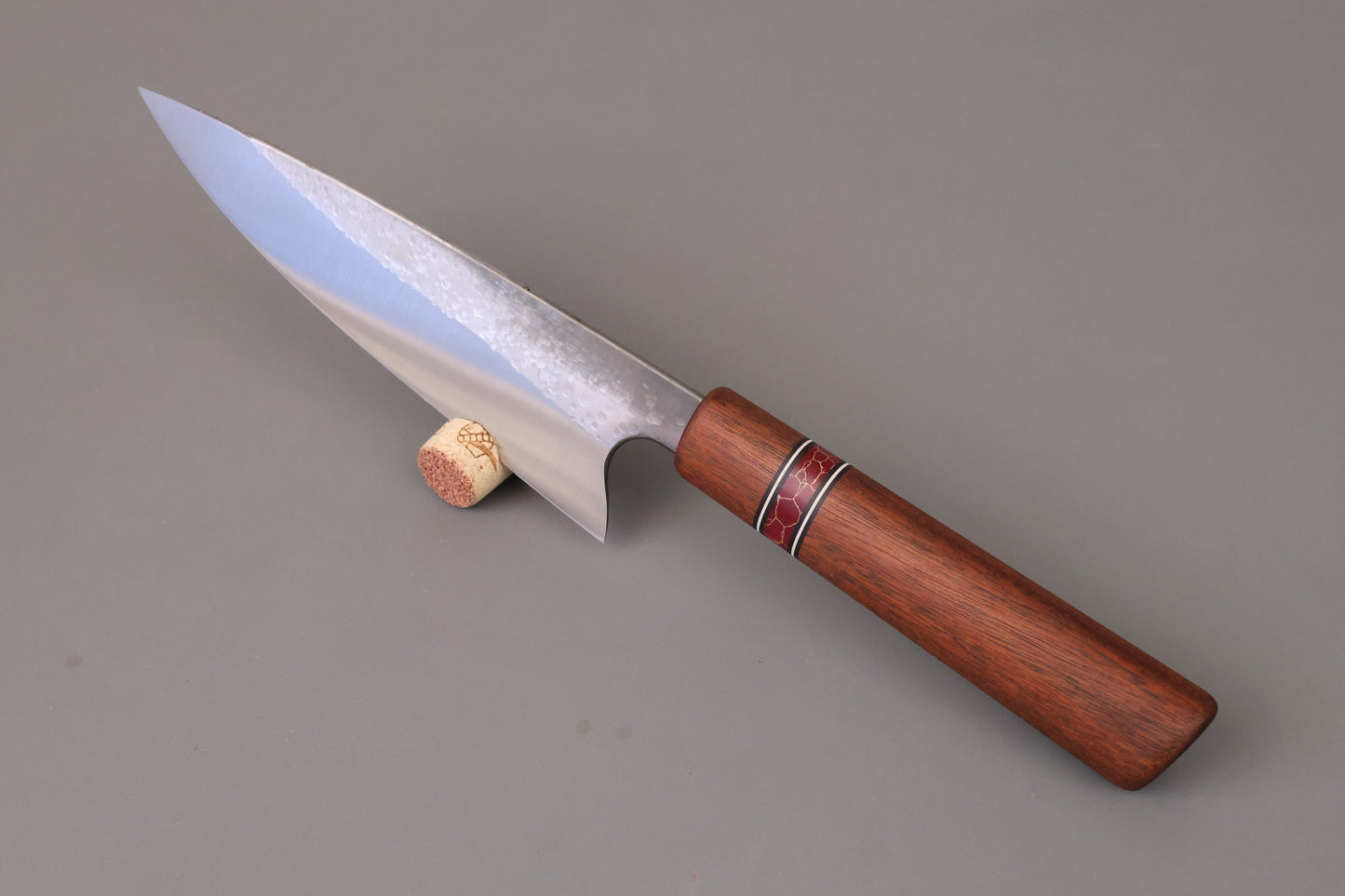 Chef knife with Ipe wooden handle on grey background.