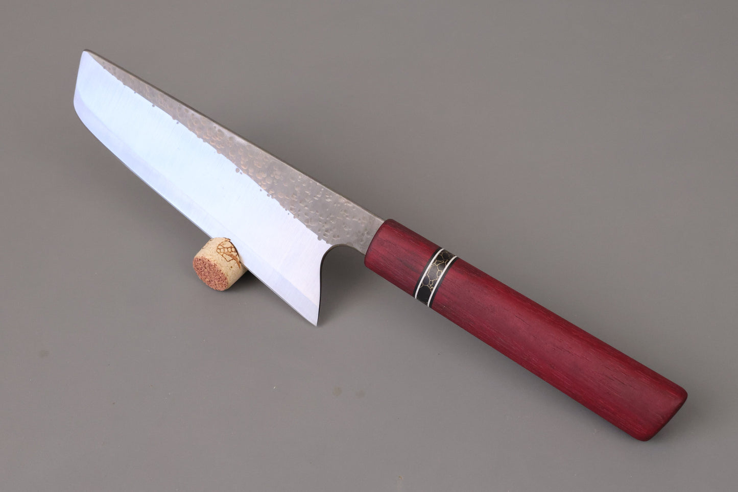 Nakiri kitchen knife with S-grind and Purple Hart wooden handle on gray background.