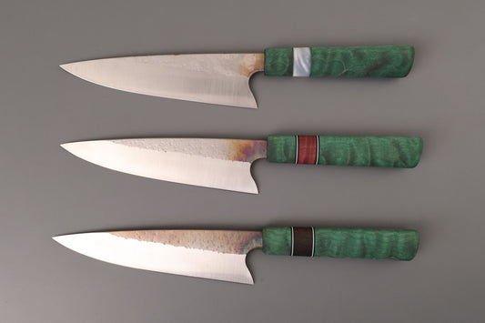 Set of three Chef knives with green handles on gray background