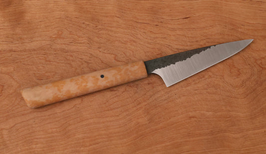 Small kitchen knife with hammered finish on wooden background