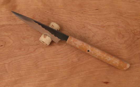 small kitchen knife in a cork on a cutting board