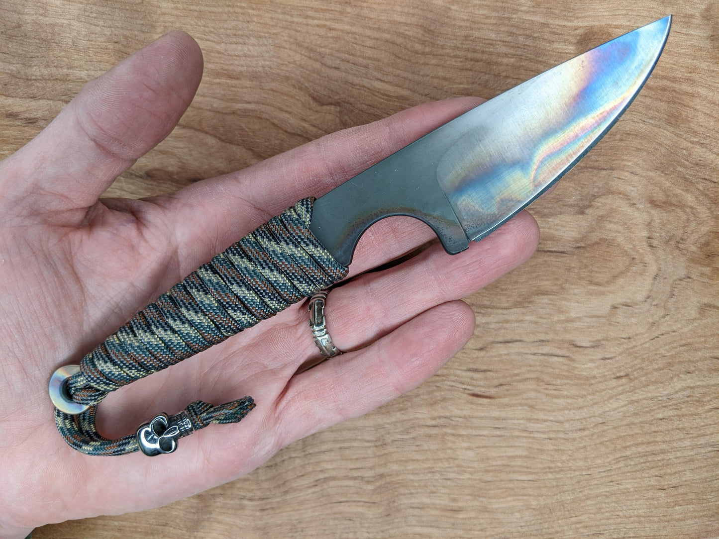 small knife handheld over wooden cutting board