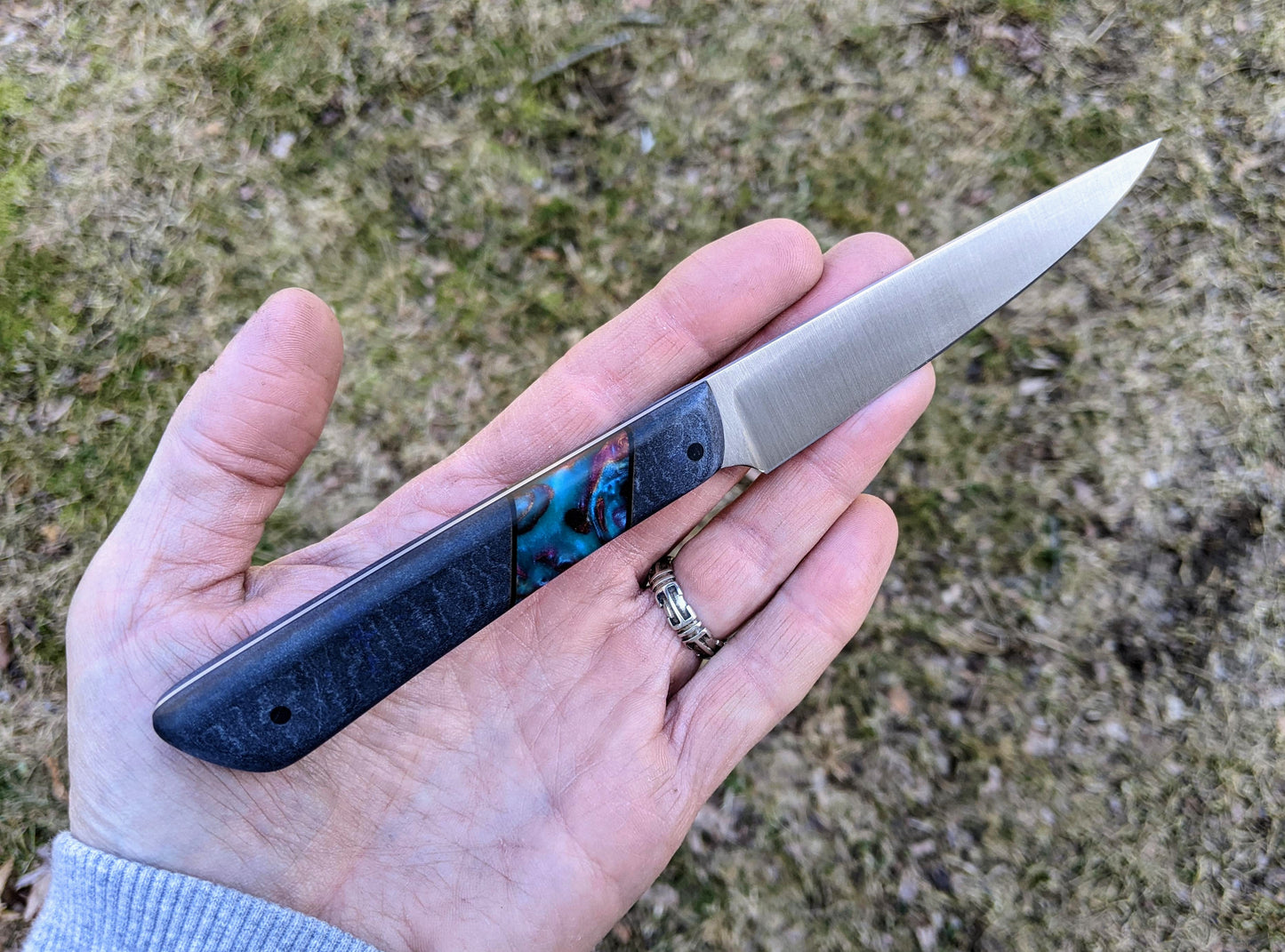 Blue paring knife held in open hand