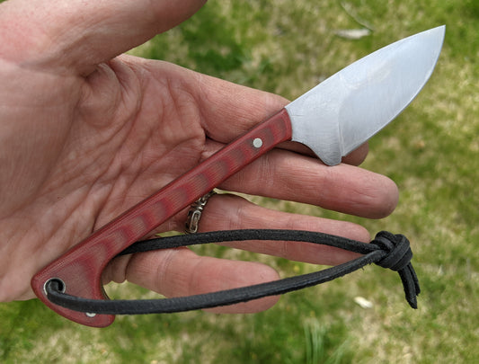 a mushroom knife with red Micarta handle