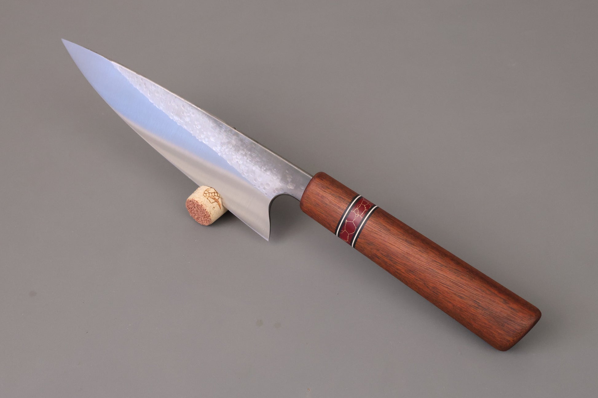 Chef knife with Ipe wooden handle on grey background. 