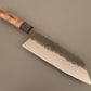 Bunka kitchen knife with hammered finish and wooden handle on gray background