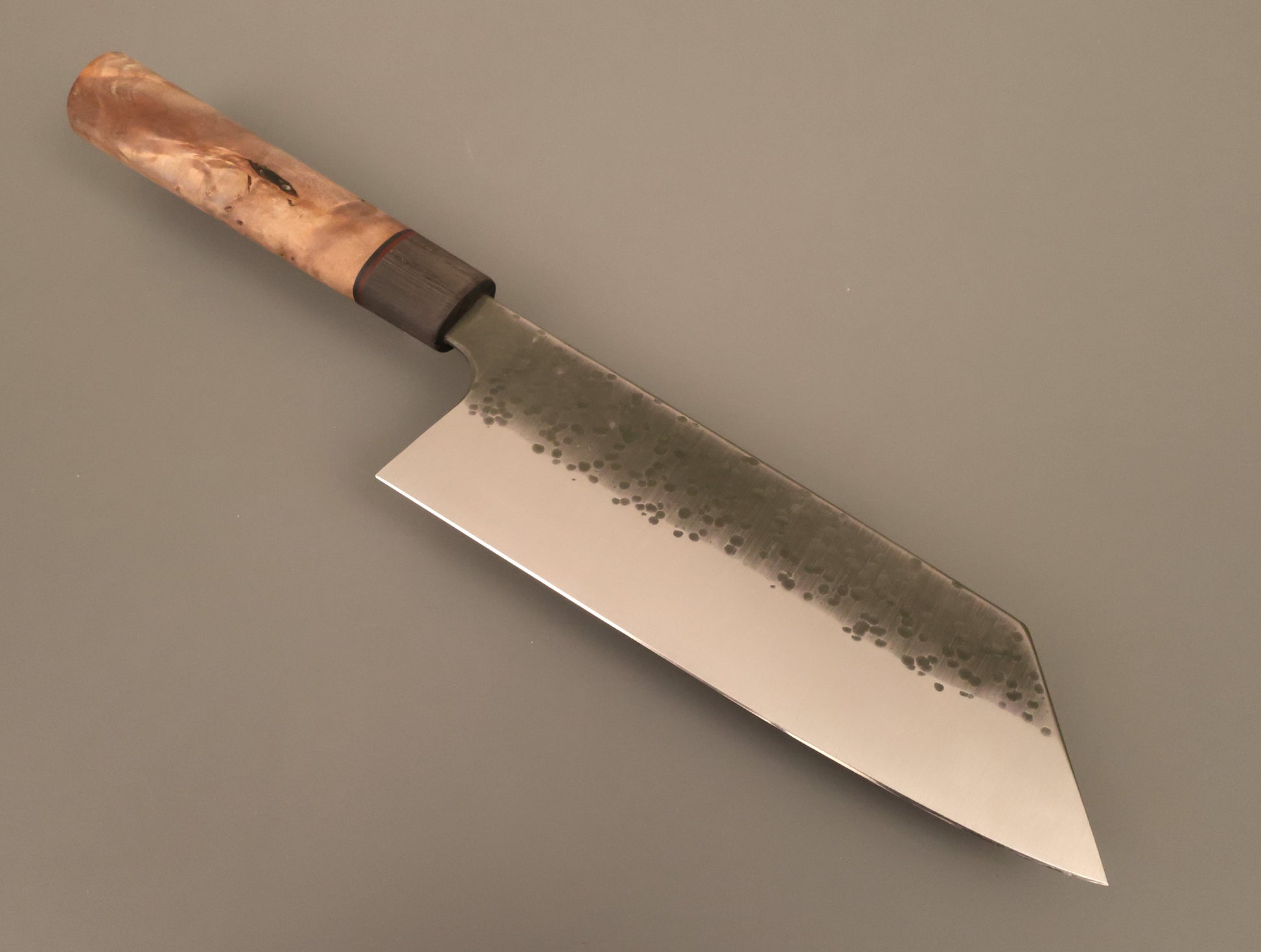 Bunka kitchen knife with hammered finish and wooden handle on gray background