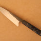 Gyuto knife with resin handle on a beige background