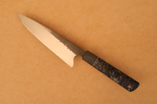 Gyuto knife with resin handle on a beige background