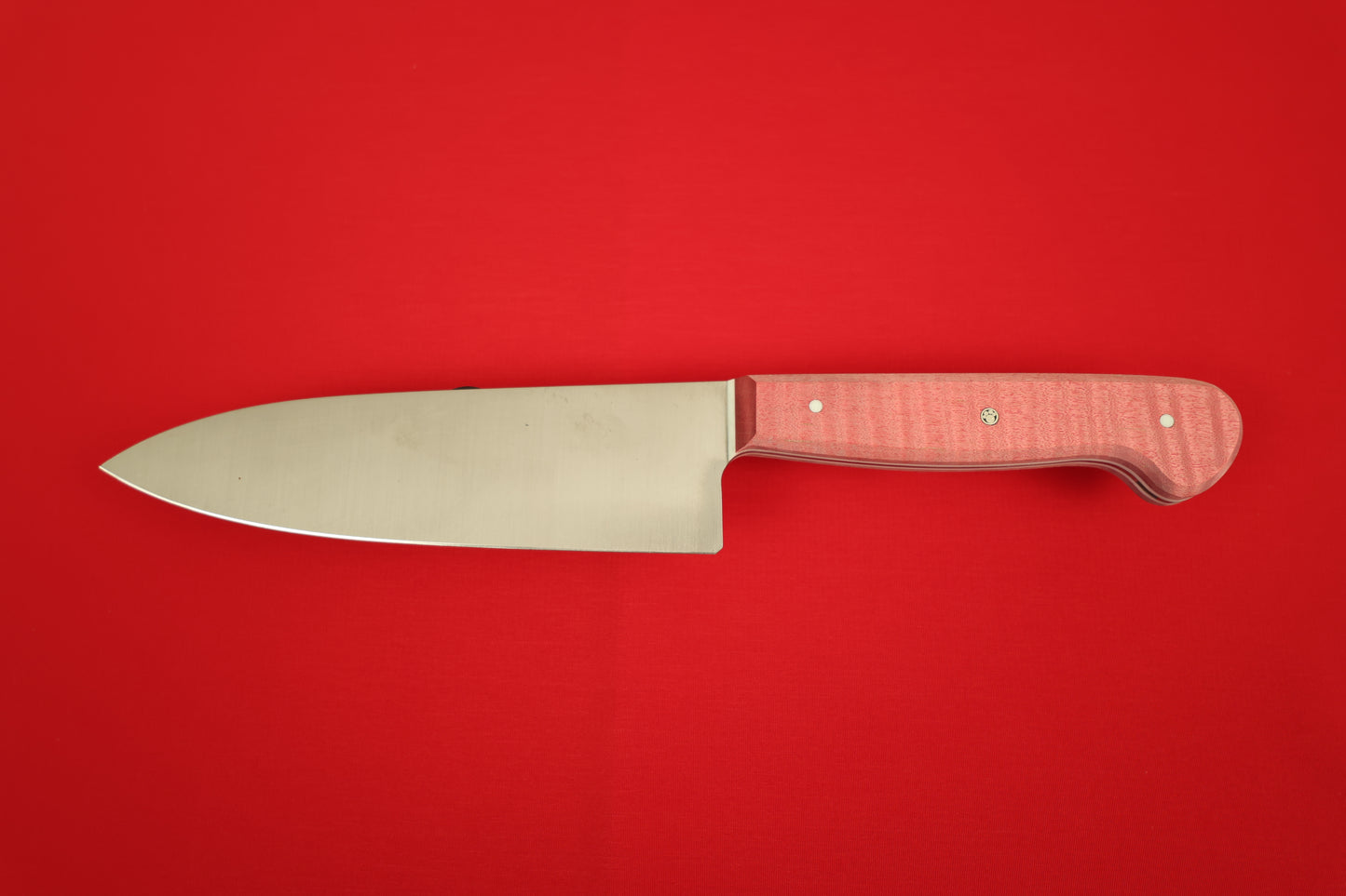 Small Chef knife with red handle on red background.