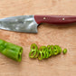 kitchen knife and pepper slices on wooden cutting board