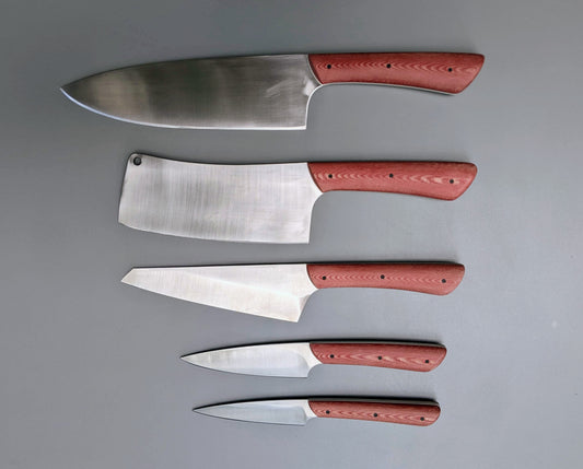 Set of kitchen knives with red Micarta handles.