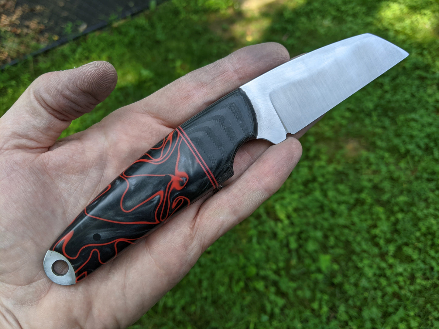Wharncliffe blade knife with black and red Kirinite handle. 