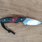 small knife with black and red handle on wooden background