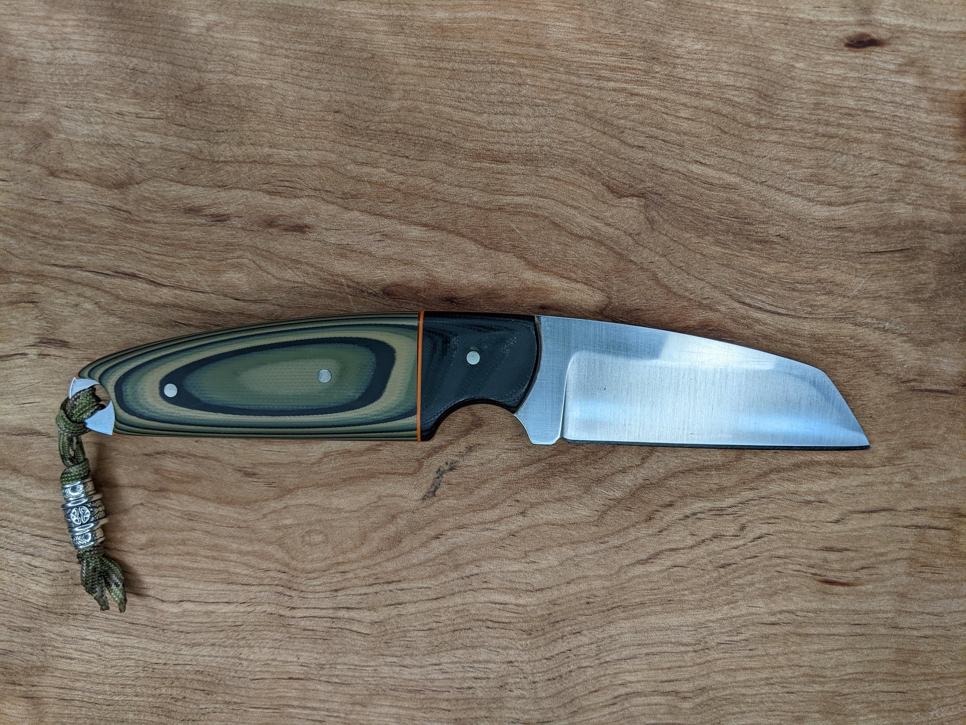 knife with sheepsfoot blade and camouflage handle on wooden backgrounds