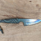 small knife with heat-treating colors and paracord wrapped handle with a metal skull bead, on wooden background