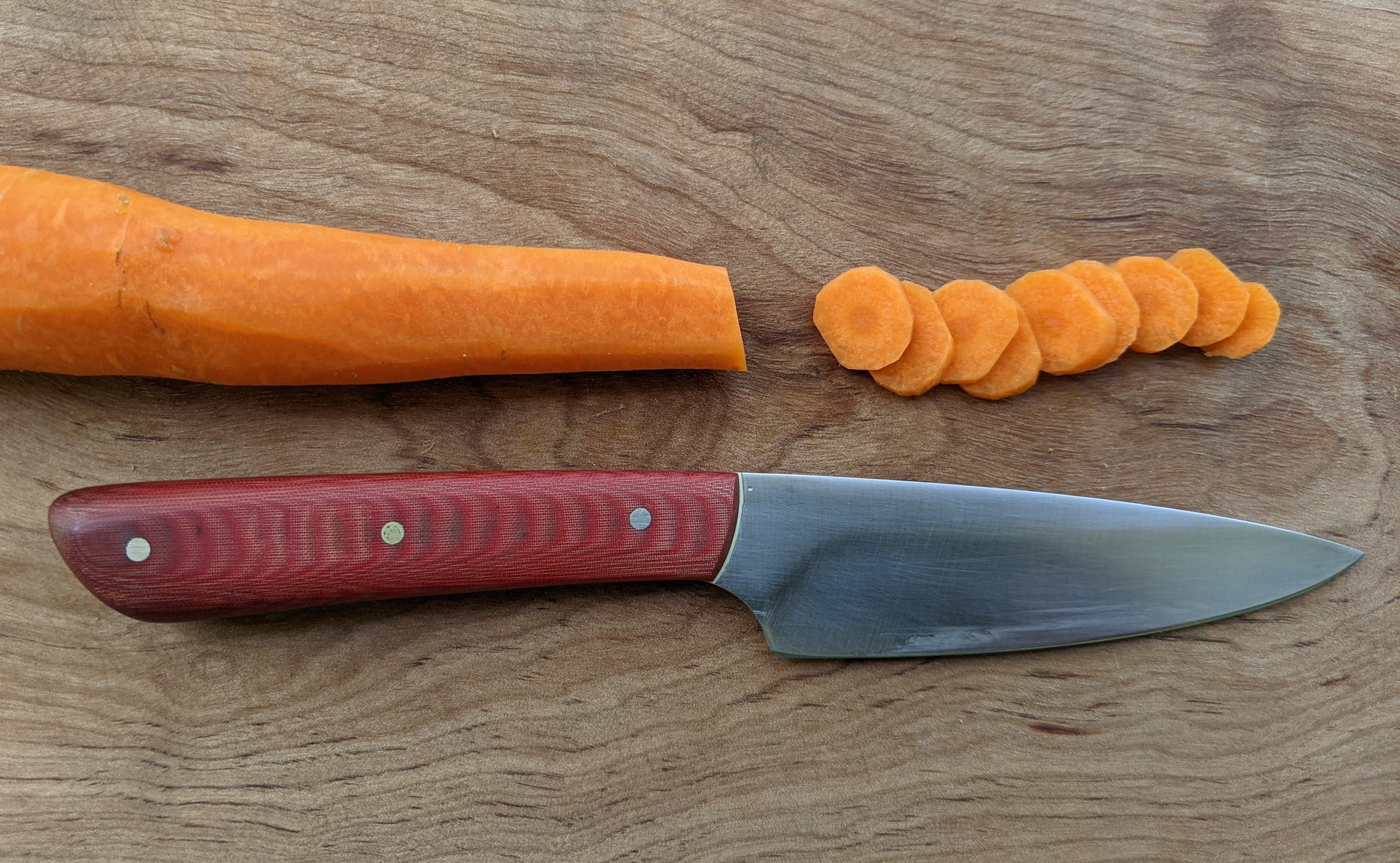 paring knife on cutting board with carrot slices 