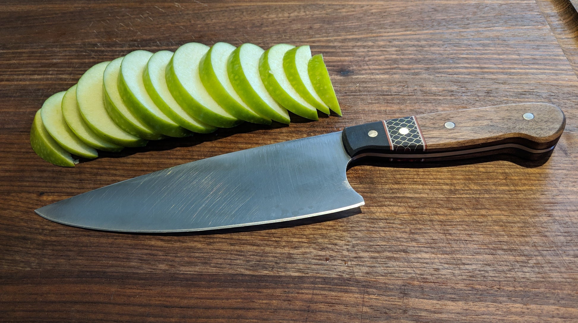 chef knife on cutting board with apple slices